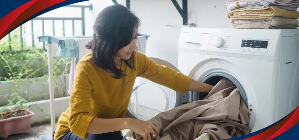 Woman in the Philippines using a front load dryer in her laundry room